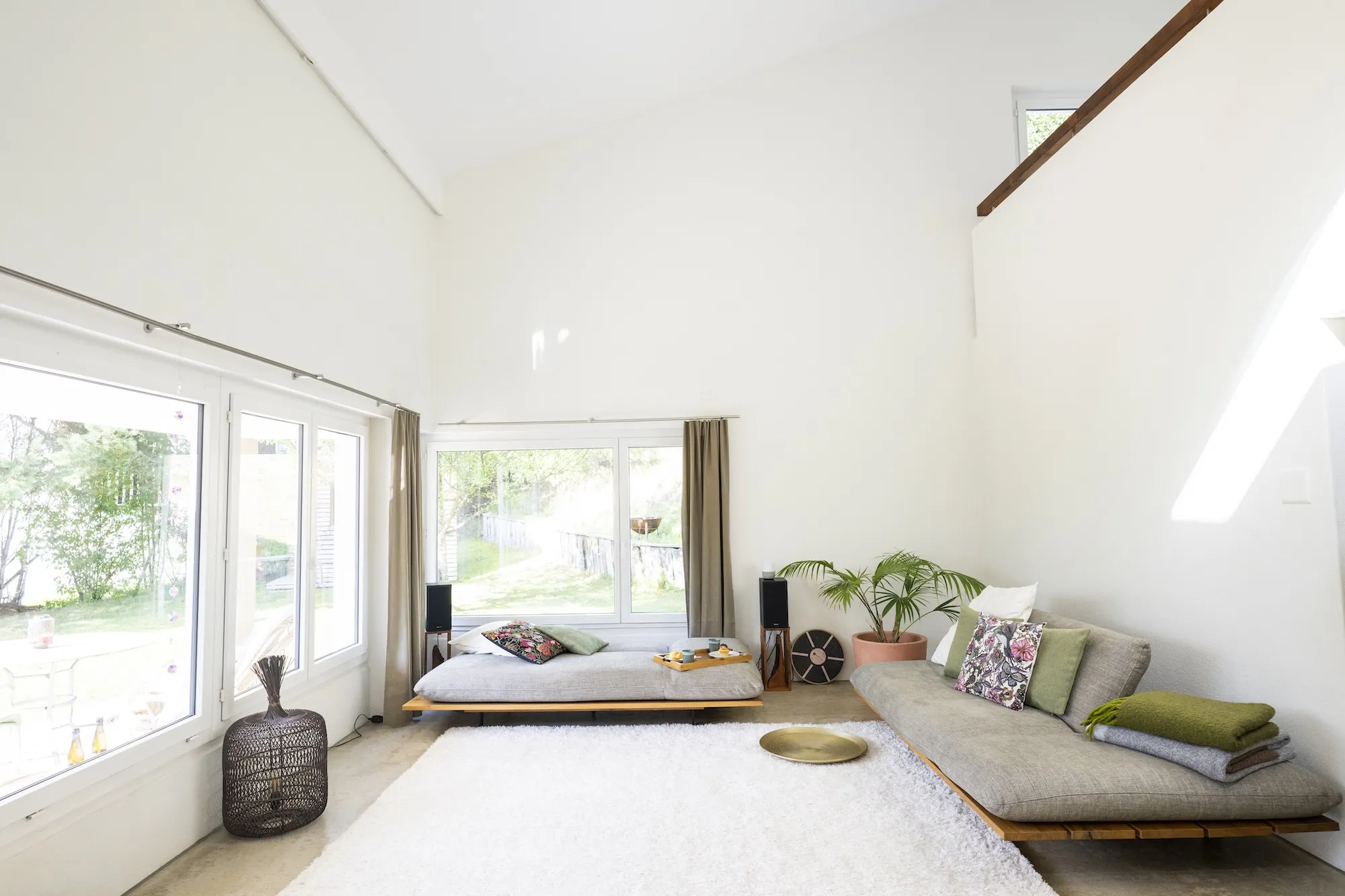 Grüne Sofas und grosse Fenster im hellen Wohnbereich